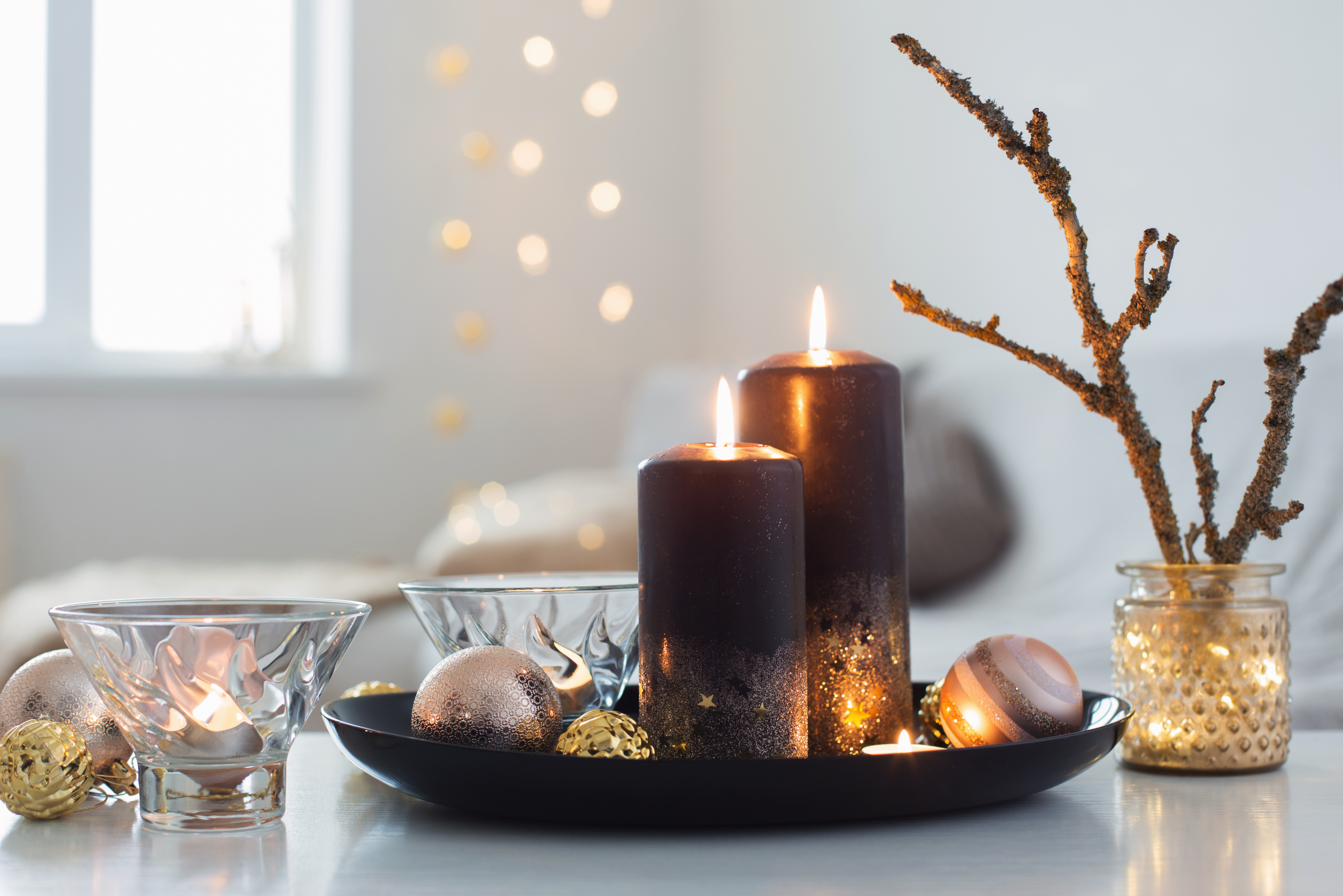 Black burning candles with Christmas balls in white interior stock photo